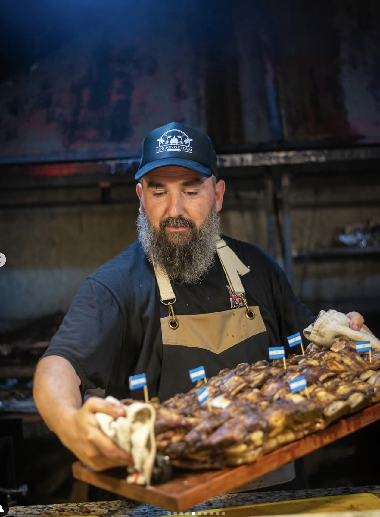 Dueño de Sin Humo presentando una bandeja con carnes asadas, en la parrilla del emprendimiento.